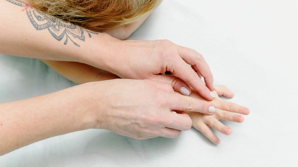 Parent réalisant un massage doux sur son bébé à la maison.